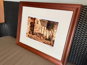 lot 217 image: Sepia Toned Wood Framed Patio Print. Frame Measuring 23 Inches Wide By 19 Inches Tall. Artist Andy Hall.