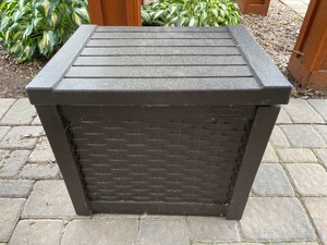 Suncast Outdoor Storage Box End Table with Birdseed, Charcoal Briquettes and Lighter Fluid Inside.