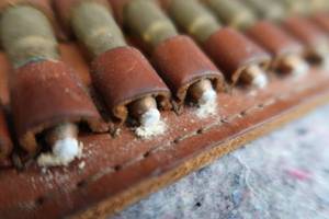 lot 49 image: VINTAGE AMMO IN LEATHER CARTRIDGE HOLDER