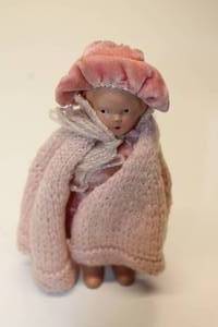 lot 37 image: Resin Doll with Hat, Dress and Hand-Knitted Shawl