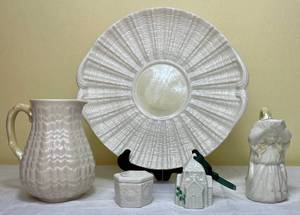 lot 119 image: Belleek Ireland Porcelain Milk Maid Creamer, Tridacna Pitcher with Twig Handle, Belleek Porcelain 6 sided Trinket Box, Fourth Edition Church Shaped Bell Ornament and Limpet Yellow Cake Plate