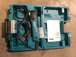 lot 12 image: Makita 3 Amp Corded Variable Speed Oscillating Multi-Tool Kit With Blade, Sanding Pad, Sandpaper, Adapter, Hard Case Customer Returns See Picture