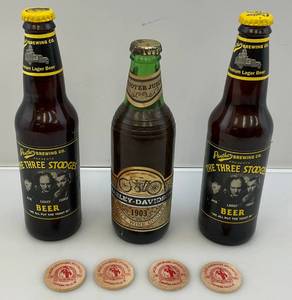 lot 86 image: Vintage Harley Davidson White Wine Cooler Bottle, Three Stooges Beer Bottles & Wooden Leinenkugel Free Beer Tokens