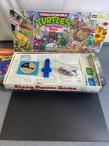 lot 129 image: 1987 Teenage Mutant Ninja Turtles TMNT Pizza Power Board Game, The Walking Dead Dice Game (New Sealed), and More