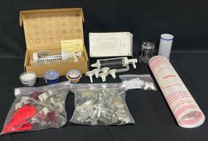 lot 45 image: Pampered Chef Cookie Press in Box, Pampered Chef Easy Accent Decorator in Box, Pampered Chef Measuring Cup, Cupcake Liners, Glass Sugar Pourer and Large Variety of Cookie Cutters
