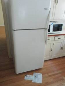 lot 4 image: Frigidaire refrigerator with top freezer section, glass drawers and shelves as well as a functional ice maker