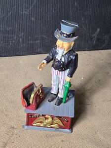lot 171 image: Uncle Sam Cast Iron Bank - Give Him the Money and He Puts it in the Bag