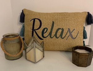 lot 57 image: RELAX Fringed Burlap Pillow with Candles