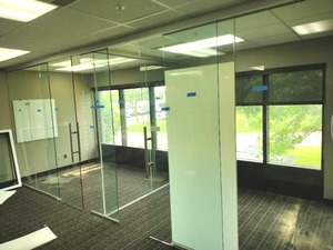 Glass Office Walls, T-Shaped configuration creates 2 modular office spaces with a glass panel divider. Sliding doors