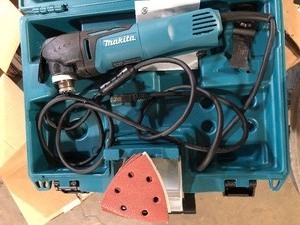 lot 40 image: Makita 3 Amp Corded Variable Speed Oscillating Multi-Tool Kit With Blade, Sanding Pad, Sandpaper, Adapter, Hard Case  Customer Returns See Pictures