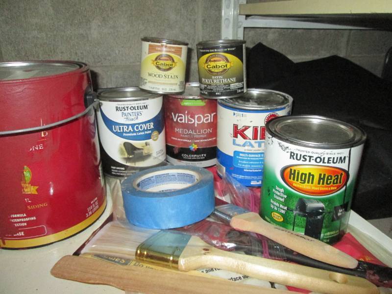 Variety of canned paints and stains as well as a handful of painting supplies