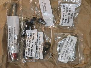 lot 243 image: 1980 Honda XR200 Parts Rocker Arm Assembly, Front Fork Cable Stay, Exhaust Nuts Bolts, Oil Drain Plug