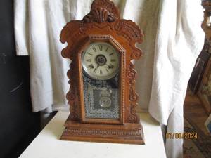 lot 57 image: Ornately carved wood encased pendul...
