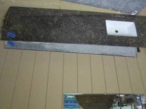 lot 356 image: Granite countertop with sink, measures 80.5 x 22. one edge is missing about an inch due to wall cutout