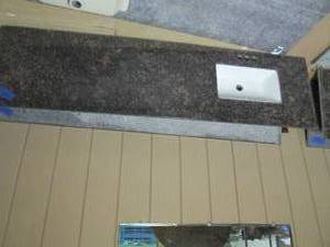 lot 358 image: Granite countertop with sink, measures 80.5 x 22. one edge is missing about an inch due to wall cutout