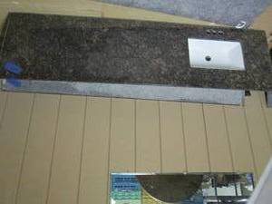 lot 361 image: Granite countertop with sink, measures 80.5 x 22. one edge is missing about an inch due to wall cutout