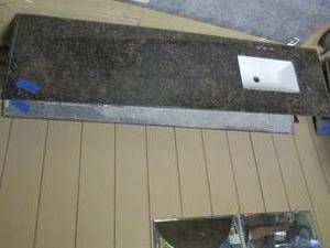 lot 362 image: Granite countertop with sink, measures 80.5 x 22. one edge is missing about an inch due to wall cutoutLot of assorted granite slabs and countertops, some are broken