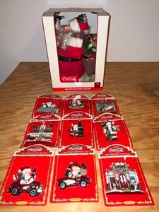 lot 13 image: BASEMENT - Coca-Cola Christmas Village Ornament Collection and Fiber Optic Tree Topper