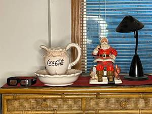 lot 493 image: BASEMENT - Coca-Cola Collectibles Lot with Ceramic Pitcher, Santa Figurine, 3D Glasses, Lamp, and Tapestry