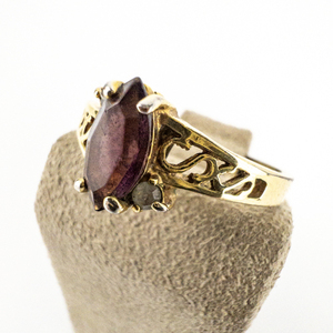 lot 48 image: Oval Cut Purple Stone (Amethyst) With CZ Side Stones & Filigree Band gold Plated Base Metal Ring. Size 10 - 10.25.