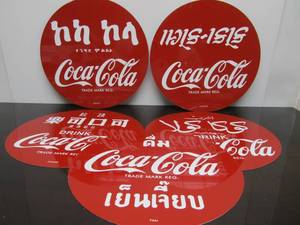 lot 106 image: Lot of 5 Metal COCA COLA Around The World Soda Signs 