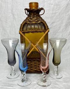 lot 56 image: Musical Decanter Bottle for H.A. Sempe Armagnac with Wicker Holder and 4 VTG Colored Stemmed Shot or Cordial Glasses