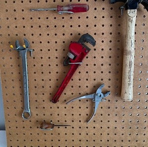 lot 318 image: TOOL Time with Pegboard, Hammer,  Adjustable Pipe Wrench, Combination Wrench, Flathead Screwdriver, Pliers, Awl, Extension Cords & CO Detector