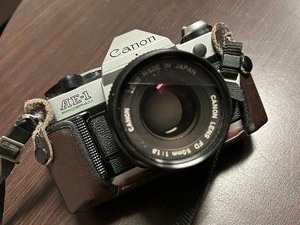 lot 113 image: Canon AE-1 Film Camera with Case, Lens and Bag