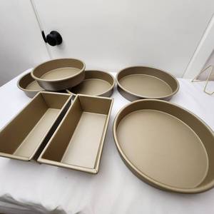 lot 81 image: Set of New Williams-Sonoma Gold Touch Baking Pans, Three 9 Inch, Two 12 Inch Rounds, and Two Loaf Pans