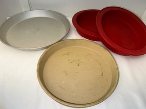 lot 94 image: Round Stoneware Baking Dish Measuring 11 Inches Diameter, A Silicone Round Baking Pan, And A Round Pizza Baking Pan
