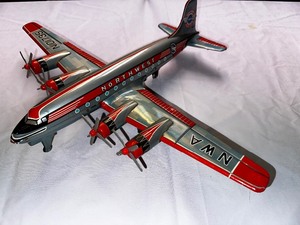 lot 327 image: Vintage NWA DC 7 Northwest Airlines Friction Powered with Turning Props Model Plane in Very Good Condition - All props turn, all tin, 16 long