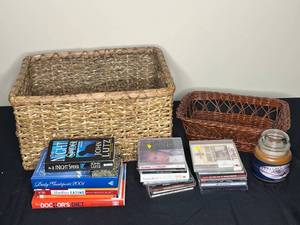 lot 99 image: Variety of Books, CDs, a candle, and 2 Wicker Baskets - All titles unknown