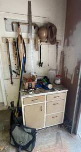 lot 63 image: Everything Pictured Goes Garage Cabinet, Garage Items, Helmet, Hat, Bungee Cords, Fireplace Maintenance Tools, Garden Tools, Hand Tools and More