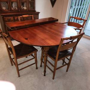 Antique Table with Four Chairs Includes One Armchair , All with Woven Seats. Table Has Drop Sides and Comes with Three Matching Leaves. Measuring 48 Inches In Diameter x  Extendable To 78 Inches