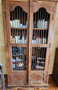 lot 3 image: Antique Cupboard or Cabinet, Wine Cabinet featuring Solid Wood Construction with Three Shelves, Front Doors are Made with Wood and Iron with Hand Carved Detailing on the bottom. contents not included - shelf only