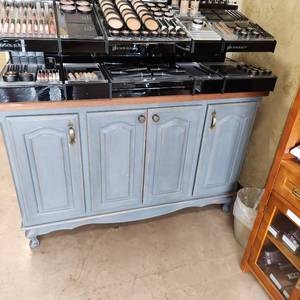 lot 24 image: Solid Wood Smokey Grey Blue Painted Buffet Cabinet with Wood Top and Four Doors that Open for Storage. Measuring 49 inches W by 22 inches D by 32-12 inches H. Cabinet Only, Contents Not Included