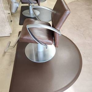lot 44 image: Salon Barber Hydraulic Lift Chair features tailord brown vinyl upholstery and chrome hydraulic base includes Anti-Fatigue Mat. One of 16.