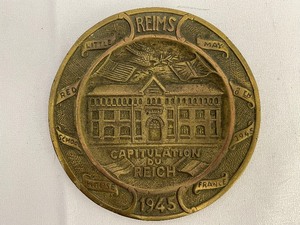 lot 18 image: Nazi Surrender Medallion. Made from WWII Nazi Shell Casing in 1945. Reims Little Red School House. May 8, 1945. Estimated Value $50-100