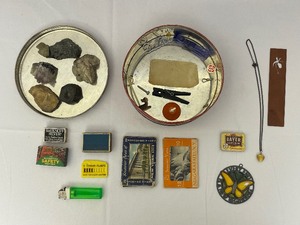 lot 127 image: Tin Full of Various Rocks, Heart Necklace, Matchboxes, and Other Trinkets.