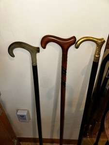lot 394 image: Mens Derby Hook Cane with Black Shaft and Horn Handle, Hand Carved Wood Cane and Metal Handle. Estimated Value for the three $150