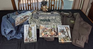 lot 92 image: Ducks Unlimited Boomer Lab Sculpture, Deer Belt Buckle, (3) 9 x 6 Chesapeake Bay, The Mississippi Flyway, and Olson Bros. Gun & Tackle Shop Tin Signs, Mens XL Jackets, Etc.