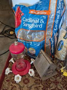 Partial Bags of Birdseed and Feeders