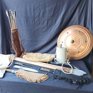 lot 48 image: Prop weapons, flint knives and spears, Prop water flask, arrows in quiver, a shield all prop quality.