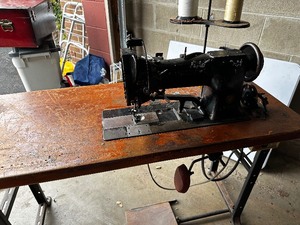 lot 126 image: Antique Singer Sewing Machine and large supply of Singer Needles, thread and notions.  This is the machine that David fitted with an electric motor to use in his costuming business.