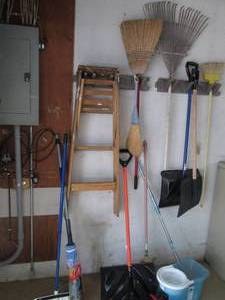Corner lot of mops, step ladder, rakes & more