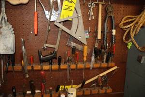 lot 599 image: Contents on Peg Board - Assorted Hand Tools - Screwdrivers, Hack Saw, Bolt Cutter, Square, Stapler, Specialty Hammer