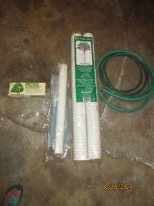 lot 297 image: Tree guards, hose, and tree and shr...