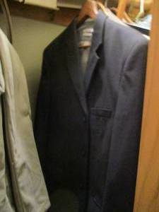 lot 563 image: Closet contents. Mens button up shirts, dress pants, hats, blankets and more