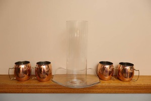lot 288 image: Four-Piece Set Copper Mule Mugs, Glass Tube Vase Cover and Platter