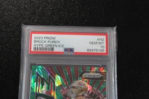 lot 16 image: 2023 Prizm Hype Green Ice Brock Purdy #H2 PSA 10